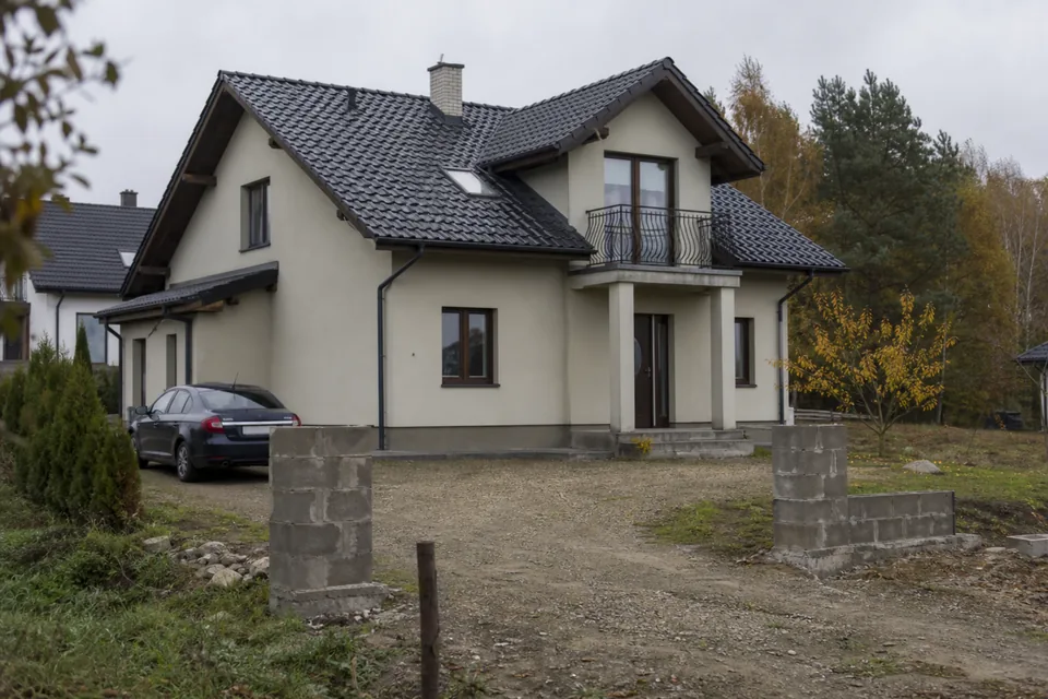 Dom jednorodzinny z lat dwutysięcznych na podmiejskiej ulicy, jesień
